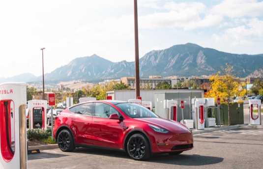 auto elektromobil Tesla Model X u nabíjecí stanice Tesla Supercharger